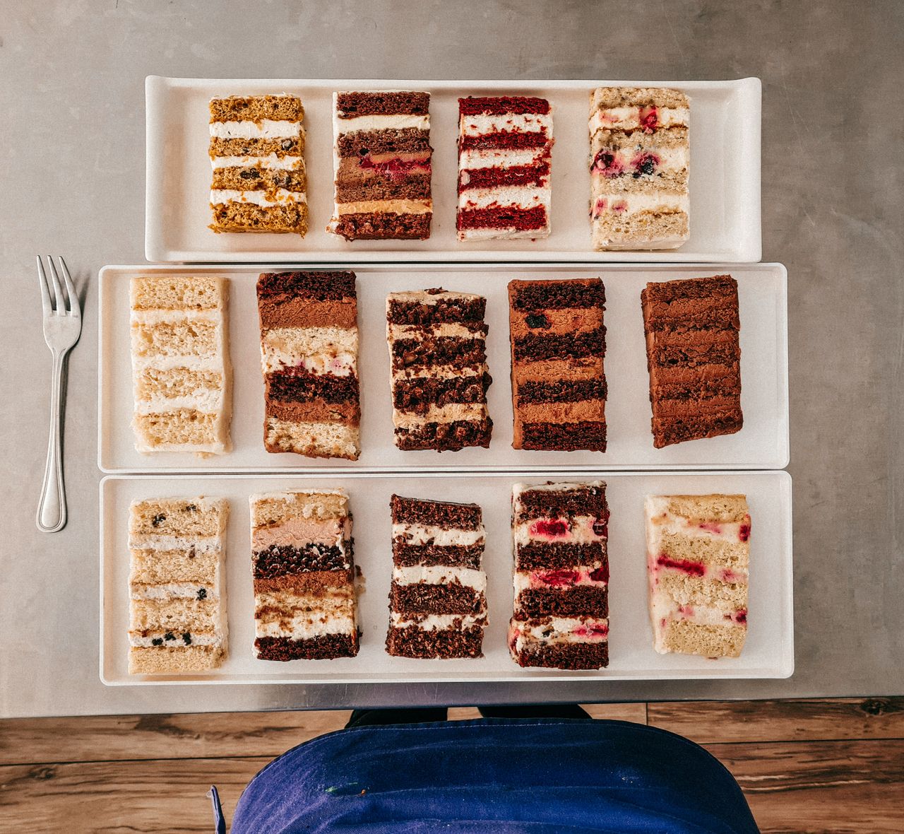 Top view of various cake slices on plates, showcasing textures and flavors.